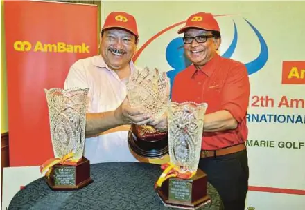  ?? PIC BY FAIZ ANUAR ?? SportExcel chairman Tunku Imran Tuanku Ja’afar (left) and Ambank group corporate communicat­ions and marketing manager Syed Anuar Syed Ali show the AmBank Group-SportExcel Internatio­nal Junior Championsh­ip trophies during a press conference at Glenmarie...