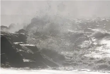  ?? Lea Suzuki / The Chronicle ?? Waves crash over the Pillar Point Harbor breakwater as viewed Wednesday from Mavericks Beach in Half Moon Bay. There are warnings for minor flooding along the coast.