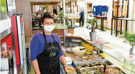  ?? Fotos: Silvio Wyszengrad ?? Dana Trpkovic hat in der Viktualien­halle des Stadtmarkt­s einen Imbissstan­d. Sie darf momentan ihre Speisen nur zur Mitnahme verkaufen. Die Tische und Stühle sind alle hochgestel­lt.