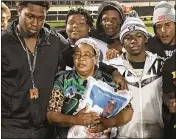  ?? PALM BEACH POST FILE PHOTO ?? Marc’Allan Derac’s mother, Marie, receives Marc’s state runner-up ring at the Eagles’ spring game against Miami Northweste­rn.