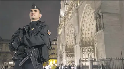  ?? JOEL SAGET/AFP/GETTY IMAGES ?? A gendarme stands guard Thursday in front of the famed Notre-Dame Cathedral in Paris. On Thursday, French Interior Minister Bernard Cazeneuve called on EU members to intensify the fight against terrorists, saying ‘all Europe must work together to...