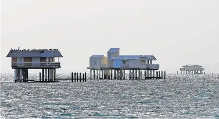  ?? ALAN DIAZ/AP ?? Hurricane Irma left the Biscayne Bay shacks of Stiltsvill­e standing, but in need of repair.