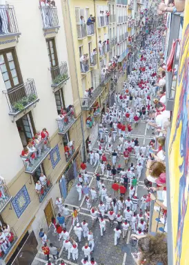  ??  ?? There is always a sea of people all in white, with red bandanas embroidere­d with their respective towns’ coat of arms, and red sashes. Visitor alert: splashing tinto (red wine) at each other is a playful practice, when people get drunk. Red blotches on...