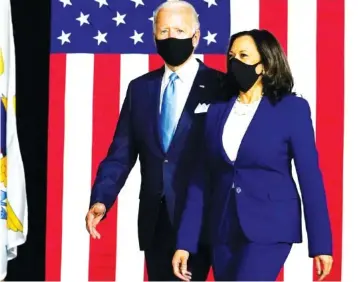  ?? AP PHOTO/CAROLYN KASTER ?? Democratic presidenti­al candidate and former Vice President Joe Biden and his running mate Sen. Kamala Harris, D-Calif., arrive to speak at a news conference Wednesday at Alexis Dupont High School in Wilmington, Del.