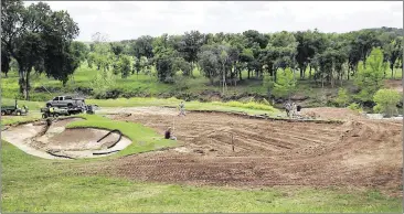  ?? RALPH BARRERA / AMERICAN-STATESMAN ?? The original front nine holes at the Onion Creek Club are scheduled to reopen in July. Here, employeesw­ork on making sure the second hole’s green is sloped so it will drain properly.