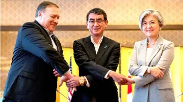  ??  ?? Pompeo, Japan’s Foreign Minister Taro Kono and South Korea’s Foreign Minister Kang Kyung Wha shake hands for members of the media as they meet in Tokyo. — Reuters photo