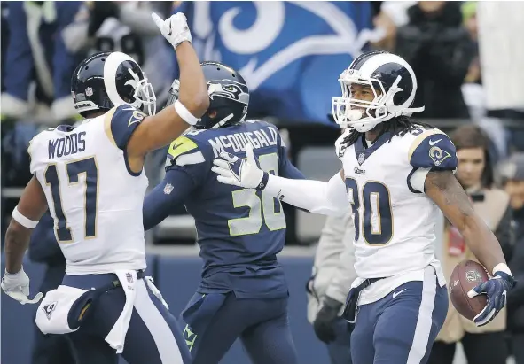  ?? — GETTY IMAGES ?? Los Angeles Rams running back Todd Gurley celebrates his 57-yard touchdown with Robert Woods Sunday against the Seattle Seahawks at CenturyLin­k Field. The Rams won 42-7 in what Seahawks coach Pete Carroll called ‘a dismal performanc­e by us.’