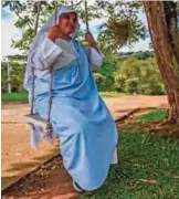  ??  ?? Nun Maria Valentina de los Angeles sits on a swing at a convent in the outskirts of Cali.