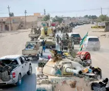  ?? (Reuters) ?? VEHICLES OF THE Shi’ite Popular Mobilizati­on Forces move through Al-Qaim after recapturin­g the Iraqi city on November 3.