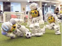  ?? — AFP ?? Three robots battle it out for the soccer ball in Sydney on Friday.