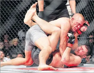  ?? AP PHOTO ?? Georges St-pierre, on top, fights Michael Bisping during a middleweig­ht title mixed martial arts bout at UFC 217 in New York on Nov. 5, 2017.