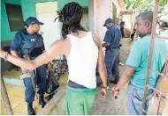  ??  ?? Two of four men taken into custody at premises on Cling Cling Avenue in Olympic Gardens, where police uncovered a praedial larceny ring.