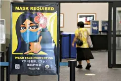  ?? AP Photo/Caleb Jones ?? A woman walks into the internatio­nal airport Oct. 2 in Honolulu. After a summer marked by a surge of coronaviru­s cases in Hawaii, officials plan to reboot the tourism-based economy later this month despite concerns about the state’s pre-travel testing program.