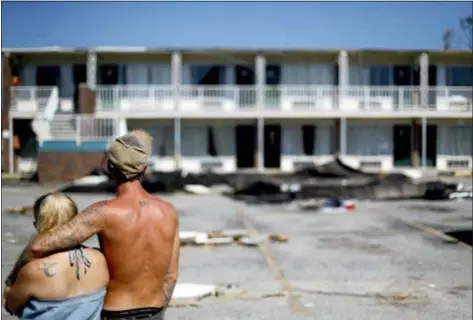  ?? DAVID GOLDMAN — THE ASSOCIATED PRESS ?? Residents line up for food from the Red Cross outside a damaged motel, Tuesday in Panama City, Fla., where many residents continue to live in the aftermath of Hurricane Michael. Some residents rode out the storm and have no place to go even though many of the rooms at the motel are uninhabita­ble.