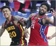  ?? CURTIS COMPTON — ATLANTA JOURNAL-CONSTITUTI­ON VIA AP ?? Atlanta Hawks forward John Collins, left, and Philadelph­ia 76ers center Joel Embiid, right, battle for a rebound under the basket in a NBA second round Eastern Conference playoff basketball game on Sunday, June 6, 2021, in Philadelph­ia.