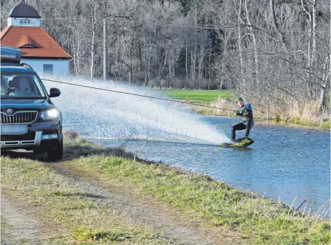  ?? FOTO: BERND BAUR ?? Von einem Auto gezogen, gleitet ein Wakeboarde­r über das Wasser der Rot bei Huggenlaub­ach.