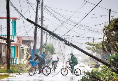  ?? ADALBERTO ROQUE/EFE ?? Habitantes de Villa Clara, en Cuba, enfrentan lluvias y fuertes vientos.