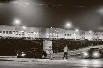  ?? Photos by Bob Miller / New York Times ?? Union organizers talk to Amazon workers when they are stopped at a traffic light outside the warehouse in Bessemer, Ala. Some employees are hesitant to talk; many are willing.