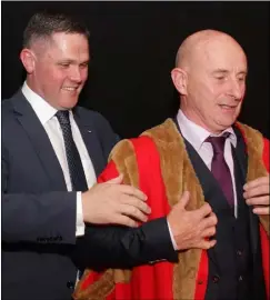  ??  ?? Cllr Frank Staples receiving his robe of office from outgoing mayor Cllr Ger Carthy last Tuesday evening.