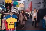 ??  ?? SEOUL: People walk past T-shirts reading ‘I heart Korea’ displayed for sale at a market. —AFP