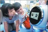  ?? HU DONGDONG / FOR CHINA DAILY ?? Children play with an intelligen­t robot at a kindergart­en in Wuhan, capital of Hubei province.