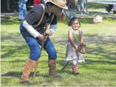  ??  ?? Lucy Stalcup, 2, helps round up bad guys with help from Allen Mack. Buffalo Solider Day was part of DreamWeek.