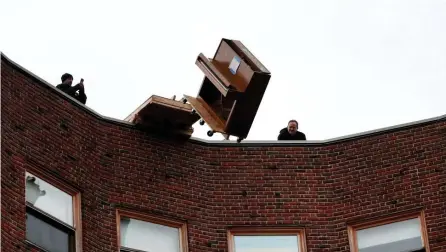  ?? NANCY LANE / HERALD STAFF ?? DROPPING A NOTE: A piano is launched off the roof of Baker House at MIT, a tradition to mark the last day of the semester students can drop a class.