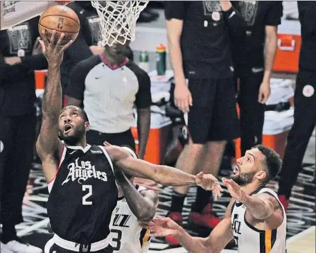  ?? Photograph­s by Gina Ferazzi Los Angeles Times ?? KAWHI LEONARD SCORES two of his 34 points on a reverse layup in second half against Utah’s Rudy Gobert, right, and Royce O’Neale.