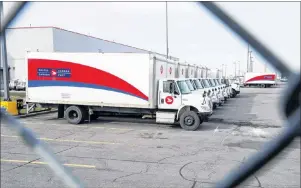  ?? CP FILE PHOTO ?? Idle Canada Post trucks sit in the parking lot of the Saint-Laurent sorting facility in Montreal as rotating strikes hit the area on Nov. 15.