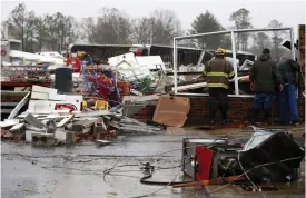  ?? AP ?? Bob Wright looks for personal belongings after a suspected tornado ripped through the town of Rosalie, killing three of his brother’s family members in Rosalie, Alabama —