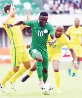  ??  ?? Nigerian forward Oghenekaro Etebo (C) runs past South African defence during the 2019 African Cup of Nations qualifying match at the Goodswill Akpabio Internatio­nal Stadium in Uyo