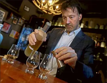  ?? Matt stone photos / boston Herald ?? Jason Waddleton, owner of the Haven in Jamaica plain, pours a whiskey as he talks about the U.s. temporaril­y suspending tariffs on products imported from the U.K. on tuesday.