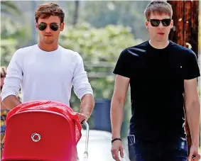  ??  ?? Family day out: New parents Tom and Dustin Lance Black