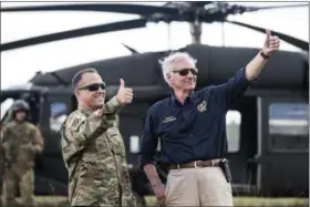  ?? SEAN RAYFORD — THE ASSOCIATED PRESS ?? South Carolina Gov. Henry McMaster, right, and National Guard Lt. Col. Jay McElveen give thumbs-up to rescue workers after Hurricane Florence struck the Carolinas, Monday near Wallace, S.C. A fire rescue team saved two people stuck on the roof of a vehicle in floodwater­s caused by the storm.