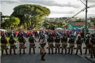  ?? Eduardo Anizelli/ Folhapress ?? Polícia Militar faz cordão de isolamento na superinten­dência da Polícia Federal no PR