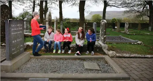  ?? Pic: ?? Inaugural Yeats Society Sligo poet-in-residence Alice Lyons reading poetry to a group of Sligo primary schoolchil­dren at Yeats’s grave in Drumcliffe, Sligo. Brian Farrell