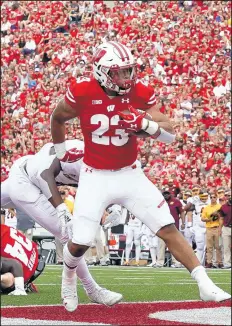  ?? MORRY GASH/AP ?? Wisconsin's Jonathan Taylor runs for one of his three touchdowns on Satuday.