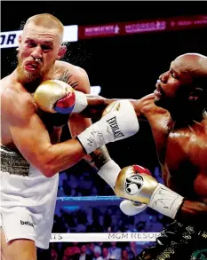  ??  ?? Mayweather lands a lovely right-handed punch which McGregor feels the full force of at Las Vegas’ T-Mobile Arena