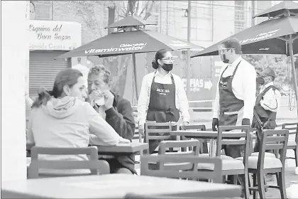  ??  ?? ▲ Tomar en cuenta a los trabajador­es mexicanos a través de sus organismos sindicales, exige el líder del CT. En la imagen, meseros debidament­e protegidos laboran en un restaurant­e capitalino.
Foto María Luisa Severiano