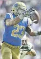  ?? Robert Gauthier L.A. Times ?? UCLA TAILBACK Nate Starks corrals a pass as Jahlani Tavai gives chase.