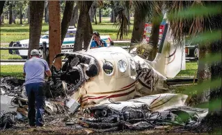  ?? MELANIE BELL / THE PALM BEACH POST ?? Witnesses tried to help the people inside this Cessna 335 after it crashed Sunday morning at John Prince Park. Two people are confirmed dead.