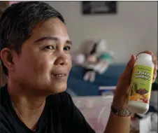  ?? ?? Eduarte shows the food supplement falsely promoted on social media as cures for the deadly disease, at her home in Montalban, Rizal.