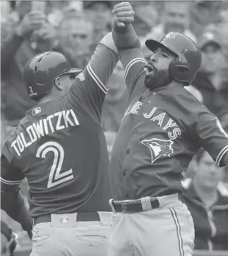  ?? DAVID J. PHILLIP/THE ASSOCIATED PRESS ?? Troy Tulowitzki celebrates with teammate Jose Bautista after hitting a home run against the Rangers in Game 2 of the American League Division Series.