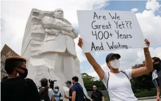  ?? JACQUELYN MARTIN
THE ASSOCIATED PRESS ?? A protester displays a placard at the Martin Luther King Jr. Memorial in Washington on Friday.