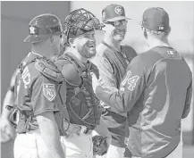  ??  ?? Astros catchers Max Stassi, second from left, and Tim Federowicz, left, laugh with manager A.J. Hinch (14). Stassi and Federowicz are competing for the same spot on the roster.