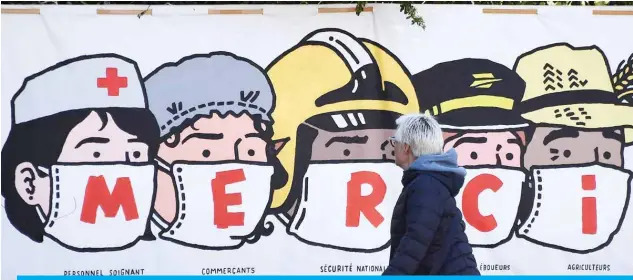  ??  ?? A person walks past a mural thanking healthcare personnel, shopkeeper­s, French national security, post office staff members and farmers in Paris on Tuesday amid a lockdown in France to stop the spread of COVID-19. —AFP