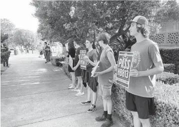  ?? KEVIN MCGILL AP ?? Anti-abortion demonstrat­ors outside the Louisiana Capitol show support for legislatio­n that would subject women who get abortions to possible murder charges on Thursday in Baton Rouge, La.