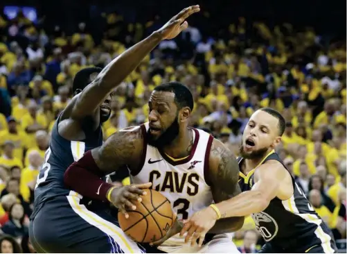  ??  ?? forward LeBron James, center, is defended by Golden State Warriors forward Draymond Green, left, and guard Stephen Curry during the second half of Game 2 of basketball’s NBA Finals in Oakland, Calif., Sunday, June 3, 2018. (AP)