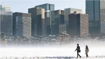  ??  ?? People walk across the snow covered ground near the Imperial Palace in Tokyo. Eleven countries aiming to forge an Asia-Pacific trade pact after the US pulled out of an earlier version will sign an agreement in Chile in March, Japan’s economy minister...