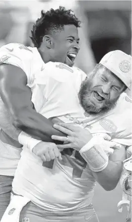  ?? DAVID BECKE/AP ?? Dolphins wide receiver Isaiah Ford, left, celebrates with quarterbac­k Ryan Fitzpatric­k after defeating the Las Vegas Raiders on Dec. 26, 2020.